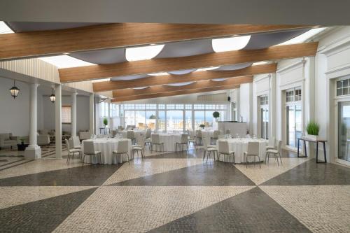 a banquet hall with white tables and chairs at Praia D'El Rey Marriott Golf & Beach Resort in Casal da Lagoa Seca
