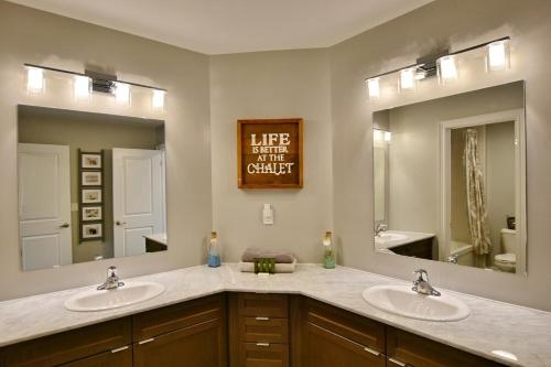 a bathroom with two sinks and two mirrors at Blue Mountain Village Townhome 4 Bedroom with Shuttle & Pool in Blue Mountains
