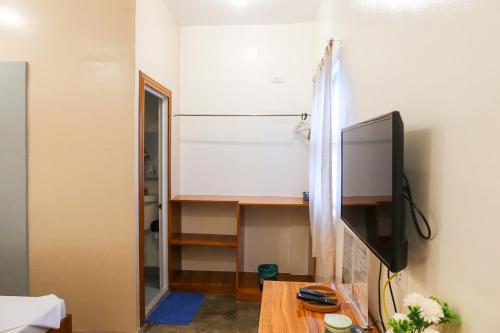 a living room with a tv and a table at AV Suites in Puerto Galera