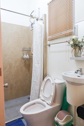 a bathroom with a toilet and a sink at AV Suites in Puerto Galera