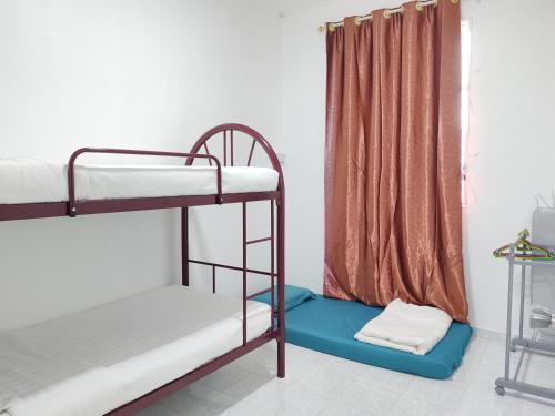 a room with two bunk beds and a curtain at Tracy Homestay Tmn Indah Jaya in Sandakan
