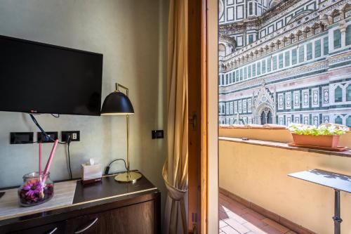 a room with a flat screen tv and a window at Hotel Duomo Firenze in Florence