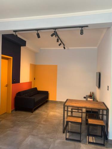 a living room with a black couch and a table at Hostel GomaPass Guarulhos Aeroporto in Guarulhos