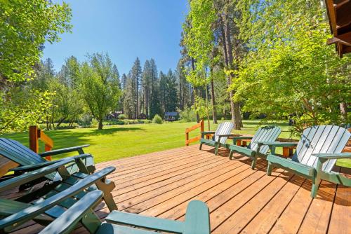 a wooden deck with chairs and tables on it at Metolius Cabin 5 in Camp Sherman