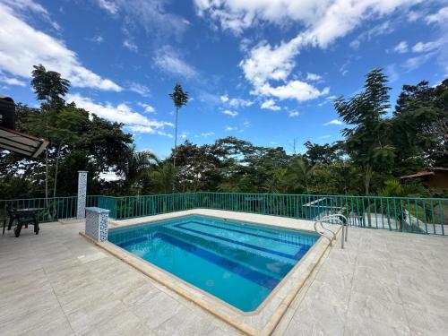 a swimming pool with a fence and a blue sky at Internacional Hostel Coffee Area in Armenia