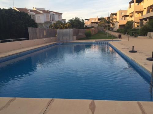 a large blue swimming pool in front of some buildings at Apartamento Rivas in Calabardina