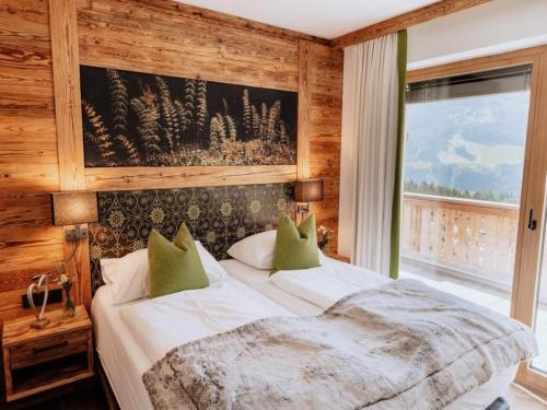 Un dormitorio con una gran cama blanca con almohadas verdes. en Nationalpark Chalet Tulpspitze, en Neukirchen am Großvenediger
