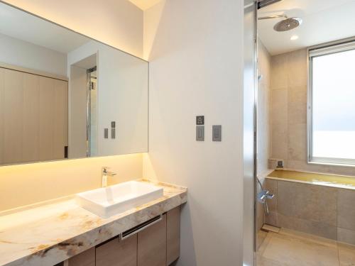 a bathroom with a sink and a mirror at KAMENOI HOTEL Arima in Kobe