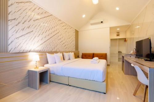 Cet appartement comprend une chambre avec un lit blanc et une cuisine. dans l'établissement i2 Resort Lampang, à Sathani Nakhon Lampang