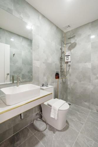 a white bathroom with a sink and a toilet at i2 Resort Lampang in Sathani Nakhon Lampang