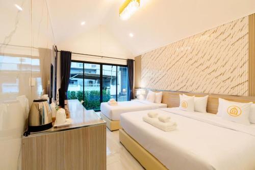 une chambre avec deux lits et une grande fenêtre dans l'établissement i2 Resort Lampang, à Sathani Nakhon Lampang