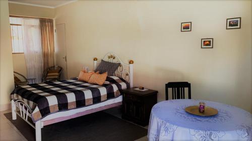 una piccola camera da letto con un letto e un tavolo di Apartamentos independientes, frente al Coliseo JRA a Sucre
