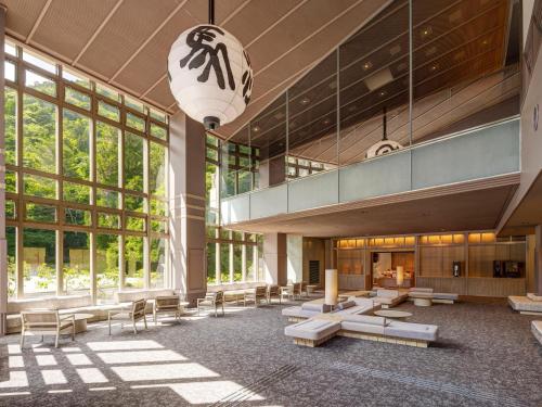 a lobby of a building with benches and windows at KAMENOI HOTEL Arima in Kobe