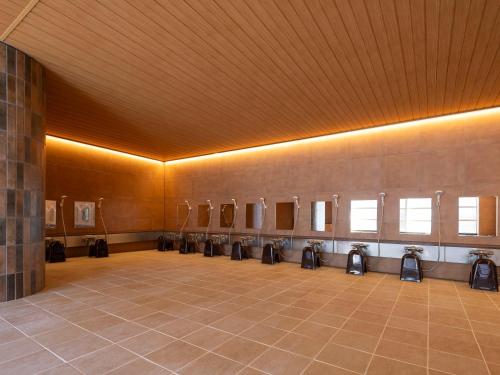 a room with a row of urinals on a wall at KAMENOI HOTEL Arima in Kobe