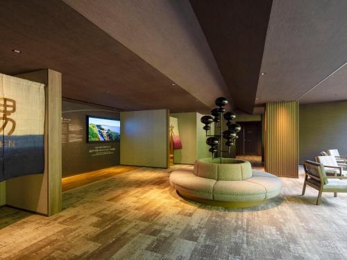 a living room with a tv and a couch and a table at KAMENOI HOTEL Arima in Kobe