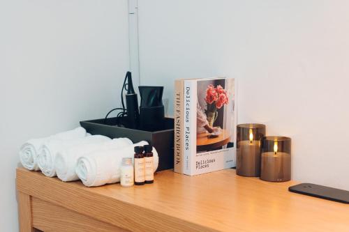 a shelf with towels and a book and candles at Restia Stay in Seoul