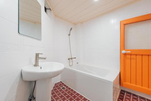 a bathroom with a sink and a bath tub at Restia Stay in Seoul