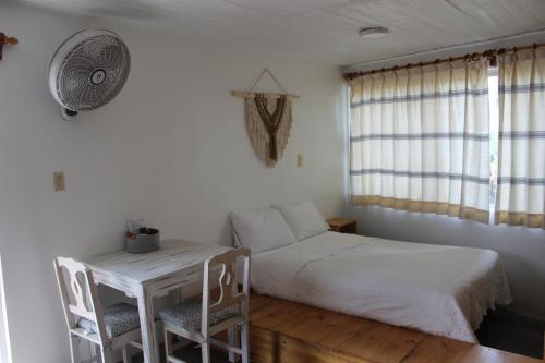 a bedroom with a bed and a table and chairs at Casa Benelaa in Oaxaca City