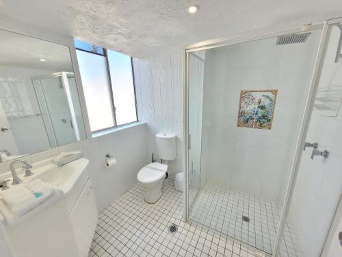 a bathroom with a shower and a toilet and a sink at Surfers Chalet in Gold Coast