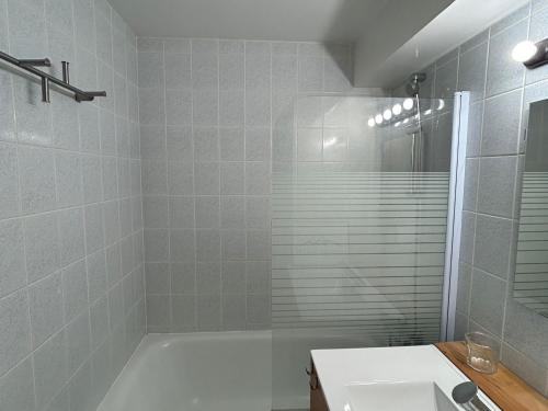 ein Badezimmer mit einer weißen Badewanne und einem Waschbecken in der Unterkunft Studio charmant au centre de la station montagne, idéal pour 2 à 4 personnes - FR-1-814-4 in Besse-et-Saint-Anastaise