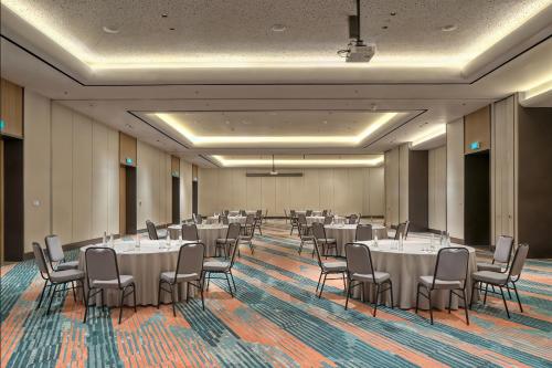 a banquet hall with tables and chairs in a room at Aloft Surabaya Pakuwon City in Surabaya