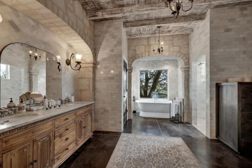 une grande salle de bain avec une baignoire et un lavabo dans l'établissement Luxurious Watershaus Ranch - Pool and Hot Tub, Fireplaces, Stunning Views!, à Morris Ranch