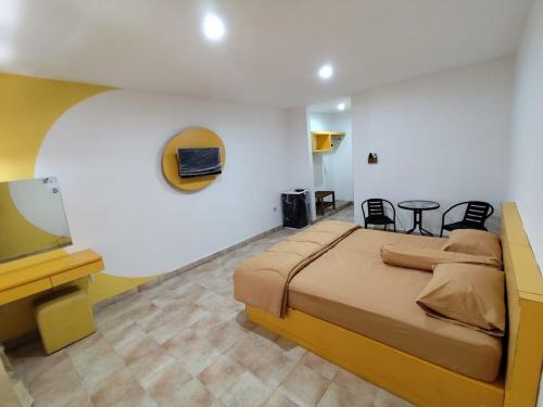 a bedroom with a large bed and a television at Puri Kedaton Hotel-Residence-Meetings in Denpasar