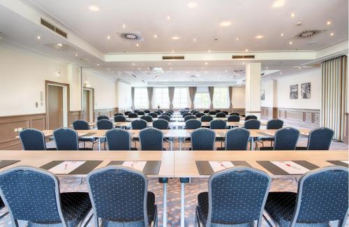 a conference room with a long table and chairs at Leonardo Hotel Hamburg Stillhorn in Hamburg