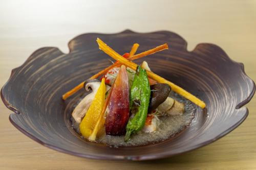 a plate of food with vegetables on a table at Ishinoya Izunagaoka - TKP Hotels & Resorts in Izunokuni