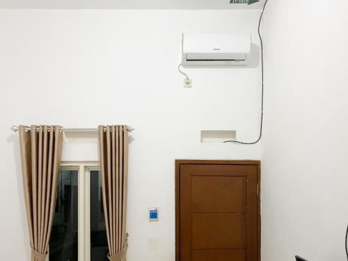 a room with a door and a air conditioner at De Zity Syariah RedPartner Near Alun Alun Jember in Jember