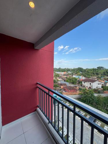 a balcony with a red wall and a view of a city at Apartamento Completo com piscina e play infantil in Ananindeua