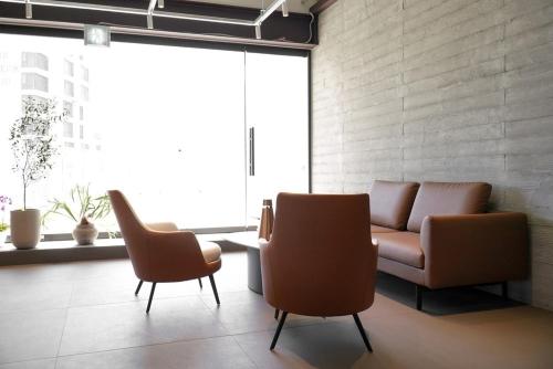 ein Wohnzimmer mit zwei Stühlen und einer Couch in der Unterkunft The Moor Pool Villa in Millak-tong