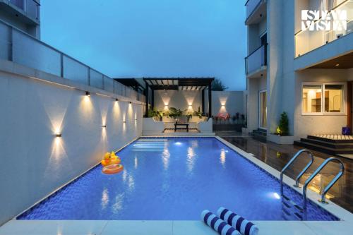 una piscina en medio de un edificio en StayVista at Amara Palms, en Igatpuri