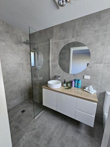 a bathroom with a sink and a mirror at George Town Villa - Outdoor Alfresco - aircon FREE WIFI - Central location near MTB Trails in George Town