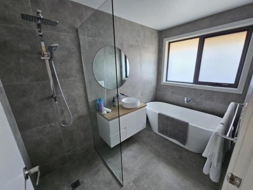 a bathroom with a tub and a sink and a mirror at George Town Villa - Outdoor Alfresco - aircon FREE WIFI - Central location near MTB Trails in George Town