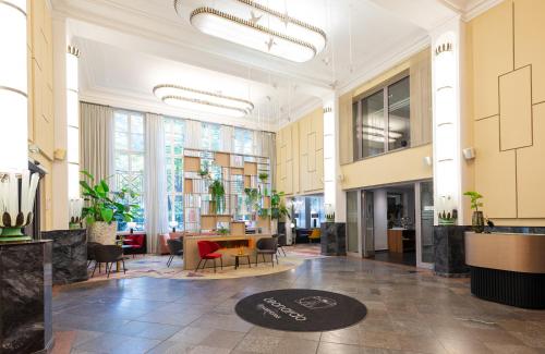 a lobby with a table and chairs in a building at Leonardo Royal Hotel Berlin Alexanderplatz in Berlin