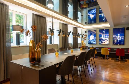 a dining room with a long table and chairs at Leonardo Royal Hotel Berlin Alexanderplatz in Berlin