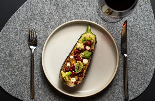 a plate with a pickle on a table with two forks at Leonardo Royal Hotel Berlin Alexanderplatz in Berlin