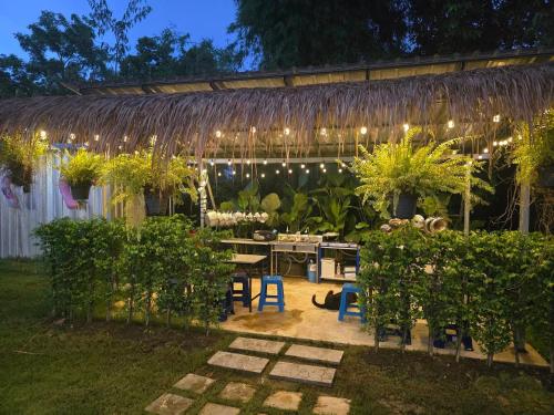 einen Garten mit einem Tisch, Stühlen und Lampen in der Unterkunft Chababarn Resort & Pool villa in Ban Nong Bua Noi