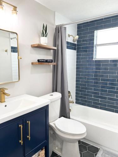 a bathroom with a toilet and a sink and a tub at Cozy Remodeled House! in Port Richey
