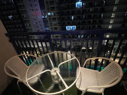 a table and chairs on a balcony at night at Premiere Haven MOA Staycation in Manila