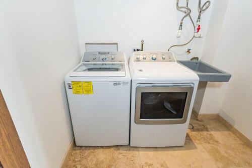 a small kitchen with a stove and a sink at Beautiful apartment with a view of the Arch in Cabo San Lucas