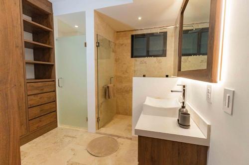 a small bathroom with a sink and a shower at Beautiful apartment with a view of the Arch in Cabo San Lucas