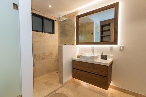 a bathroom with a sink and a mirror at Beautiful apartment with a view of the Arch in Cabo San Lucas