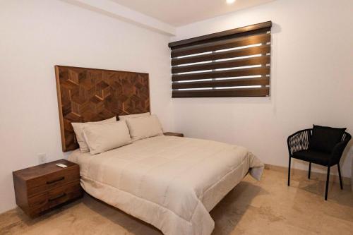 a bedroom with a bed and a chair and a window at Beautiful apartment with a view of the Arch in Cabo San Lucas
