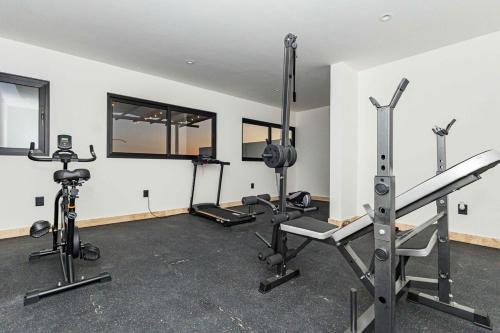 a gym with several treadmills and machines in a room at Beautiful apartment with a view of the Arch in Cabo San Lucas