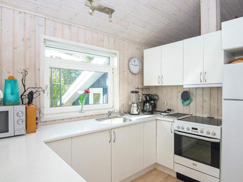 a kitchen with white cabinets and a window at Luxury Retreat near Beach - By Traum Ferienwohnungen in Sønderby