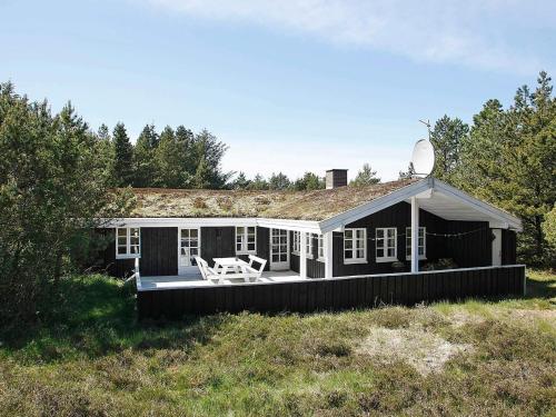 a small house with a porch and a deck at 6 person holiday home in Ålbæk-By Traum in Skram