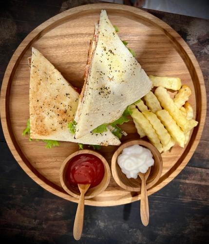 a plate with a sandwich and french fries and ketchup at Velonia Iseh in Sidemen