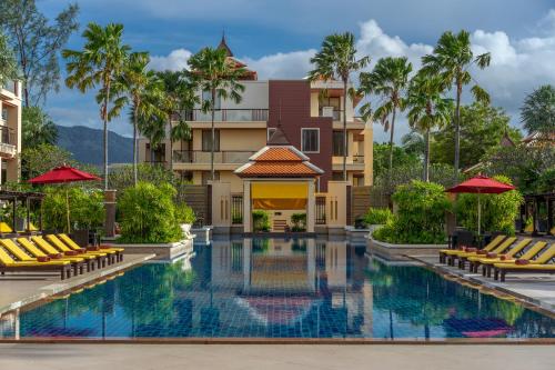 a pool at the resort with chairs and umbrellas at Mövenpick Resort Bangtao Beach Phuket in Bang Tao Beach